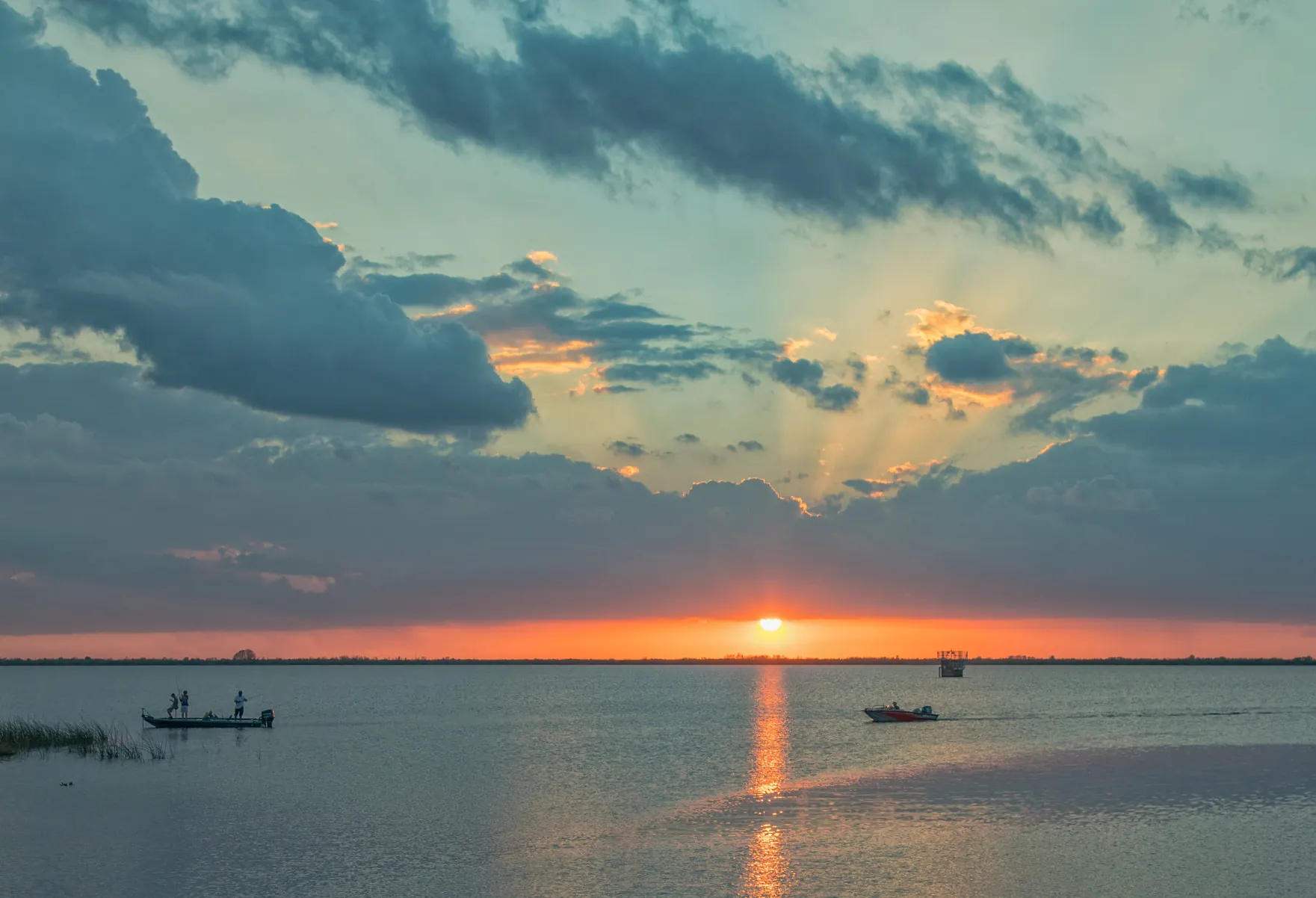 Fishing boats on calm water at sunset
